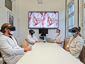 Ärzte haben VR-Brillen auf und schauen OP zu