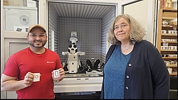 Ein Mann und eine Frau stehen vor einem geöffneten Laborschrank